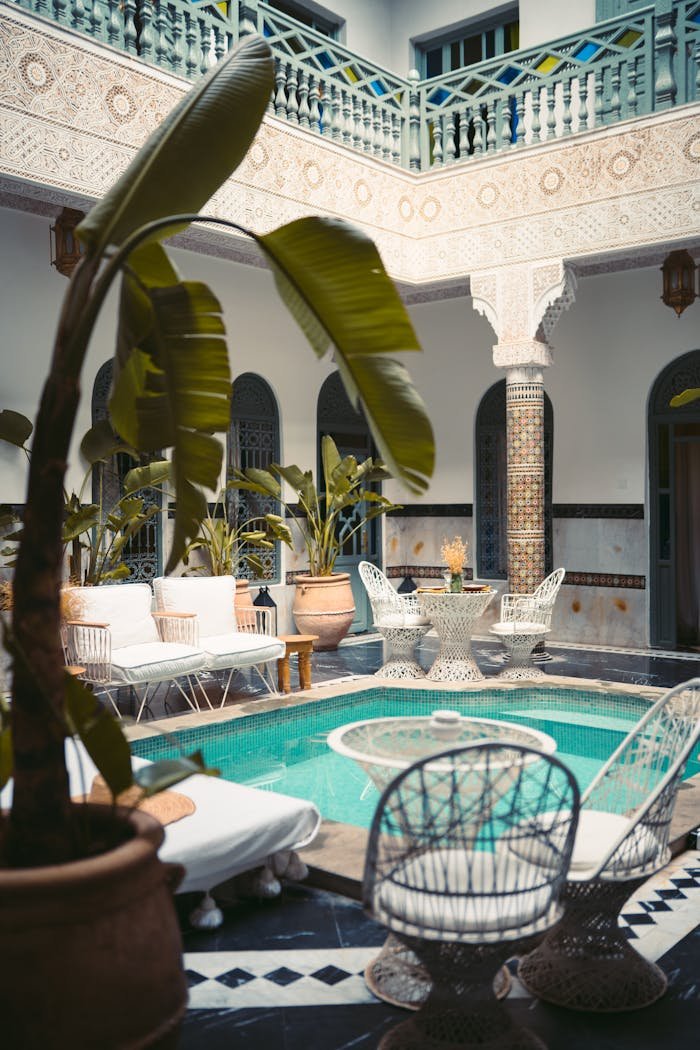 hero-gallery-02 Luxurious Moroccan courtyard in Marrakesh with a pool and ornate decor.