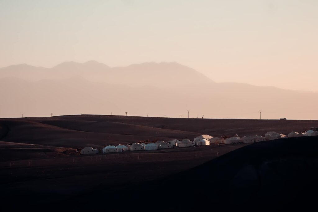 Explore the serene beauty of a village at sunset in Agafay Desert, Morocco.