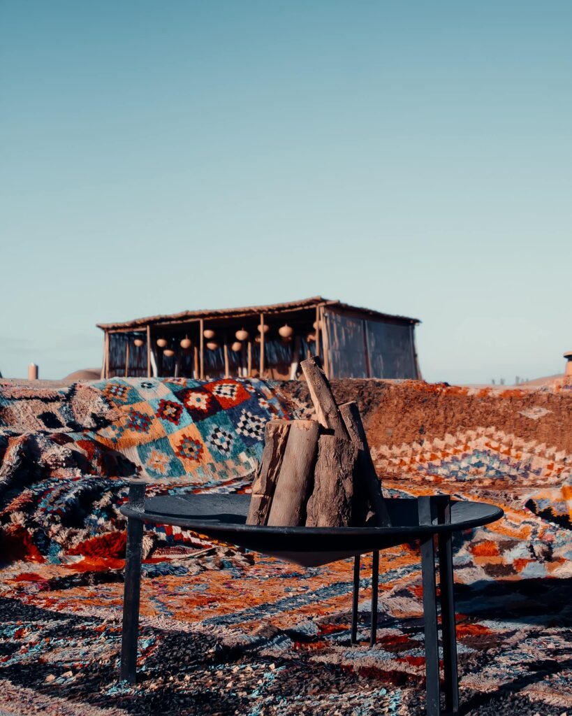 Colorful carpets and campfire in Marrakech desert camp offer a warm and adventurous atmosphere.