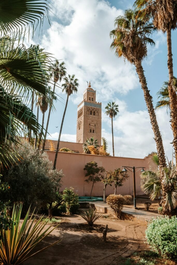 View of the Koutoubia Mosque tower surrounded by lush gardens in Marrakech, Morocco.