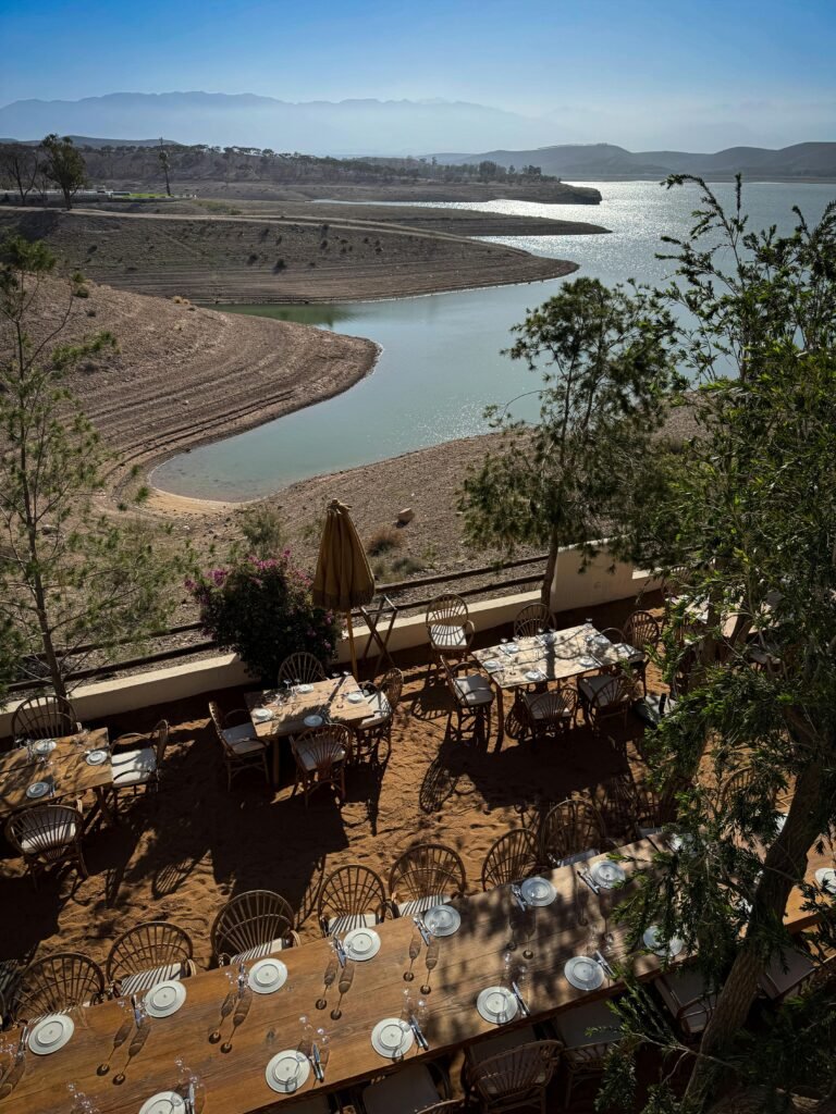 A beautiful outdoor dining setup overlooking a serene lake in Aguergour, Morocco, perfect for events.