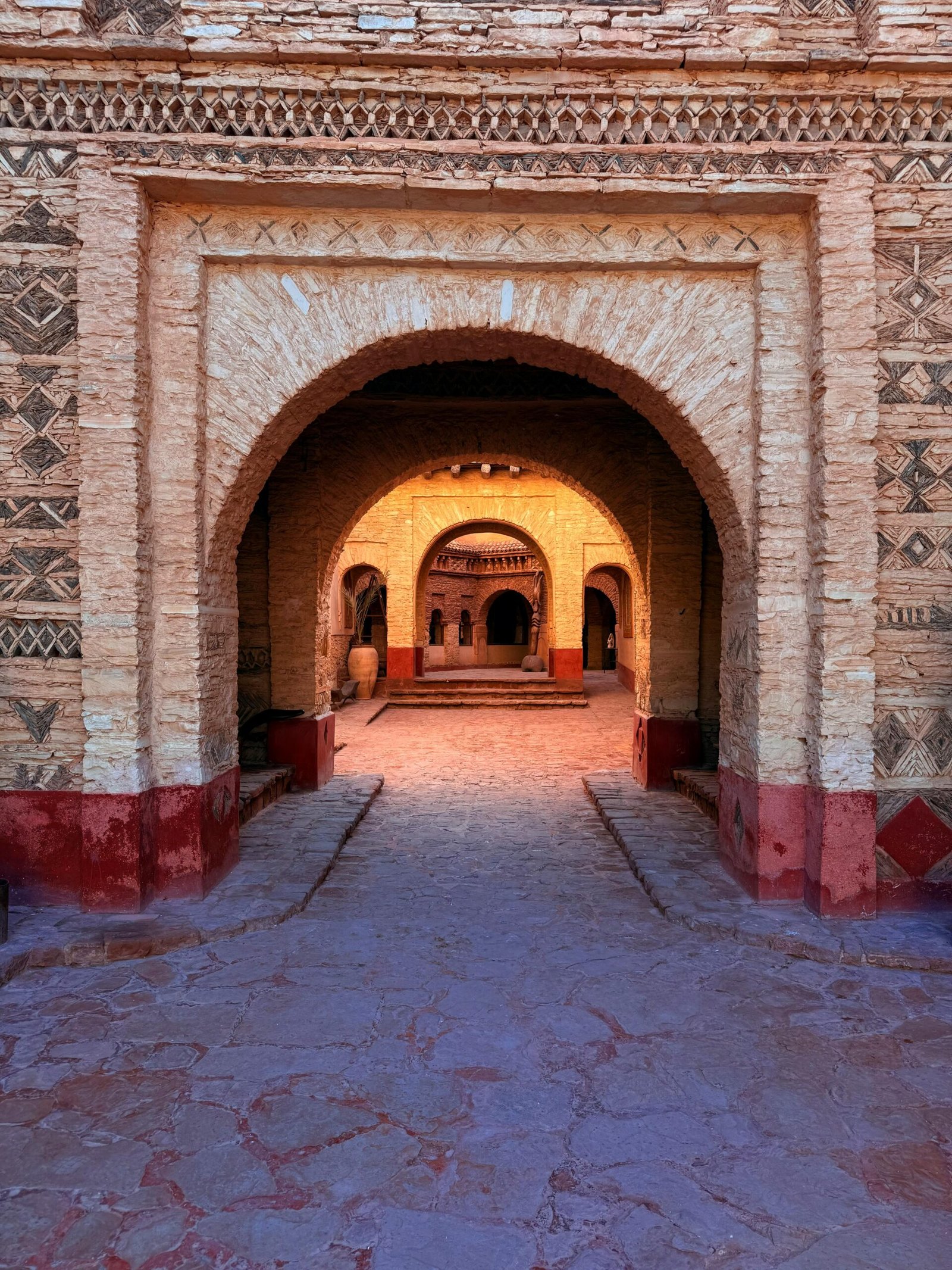 Beautiful archway in a Moroccan old medina at sunset, with intricate patterns.
