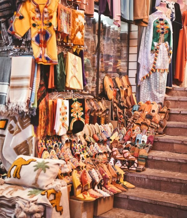 Vibrant display of traditional Moroccan garments and shoes in Agadir market.